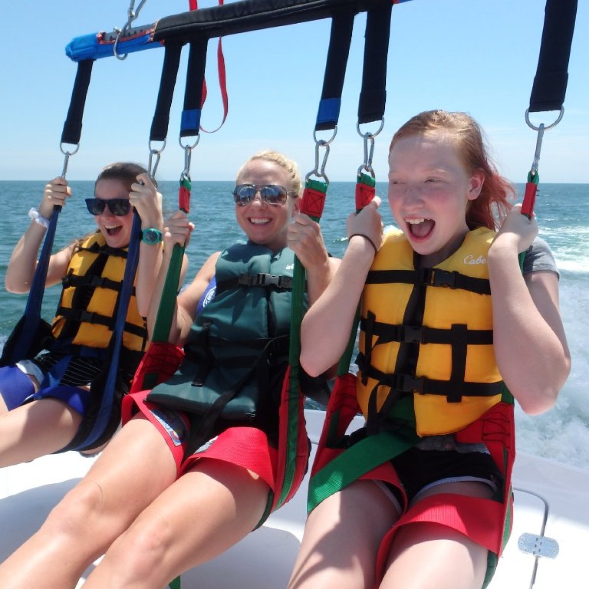 Three ladies taking flight in a parasail