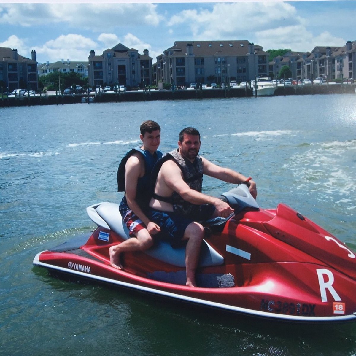 Two guys riding a red Yamaha WaveRunner Jet Ski in Virginia Beach