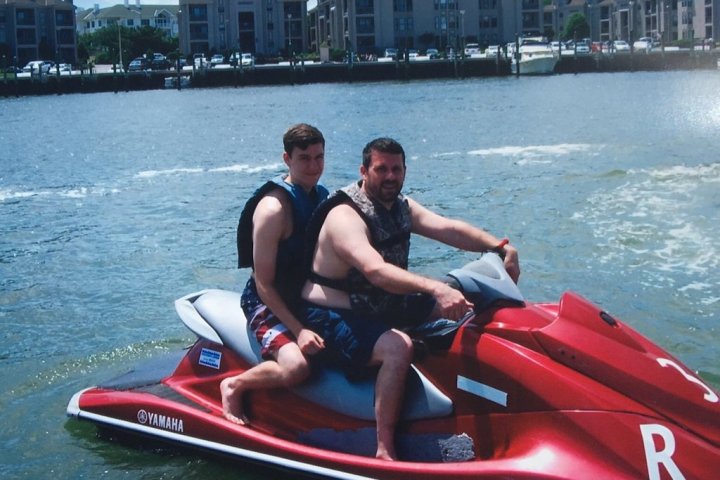 Two guys riding a red Yamaha WaveRunner Jet Ski in Virginia Beach