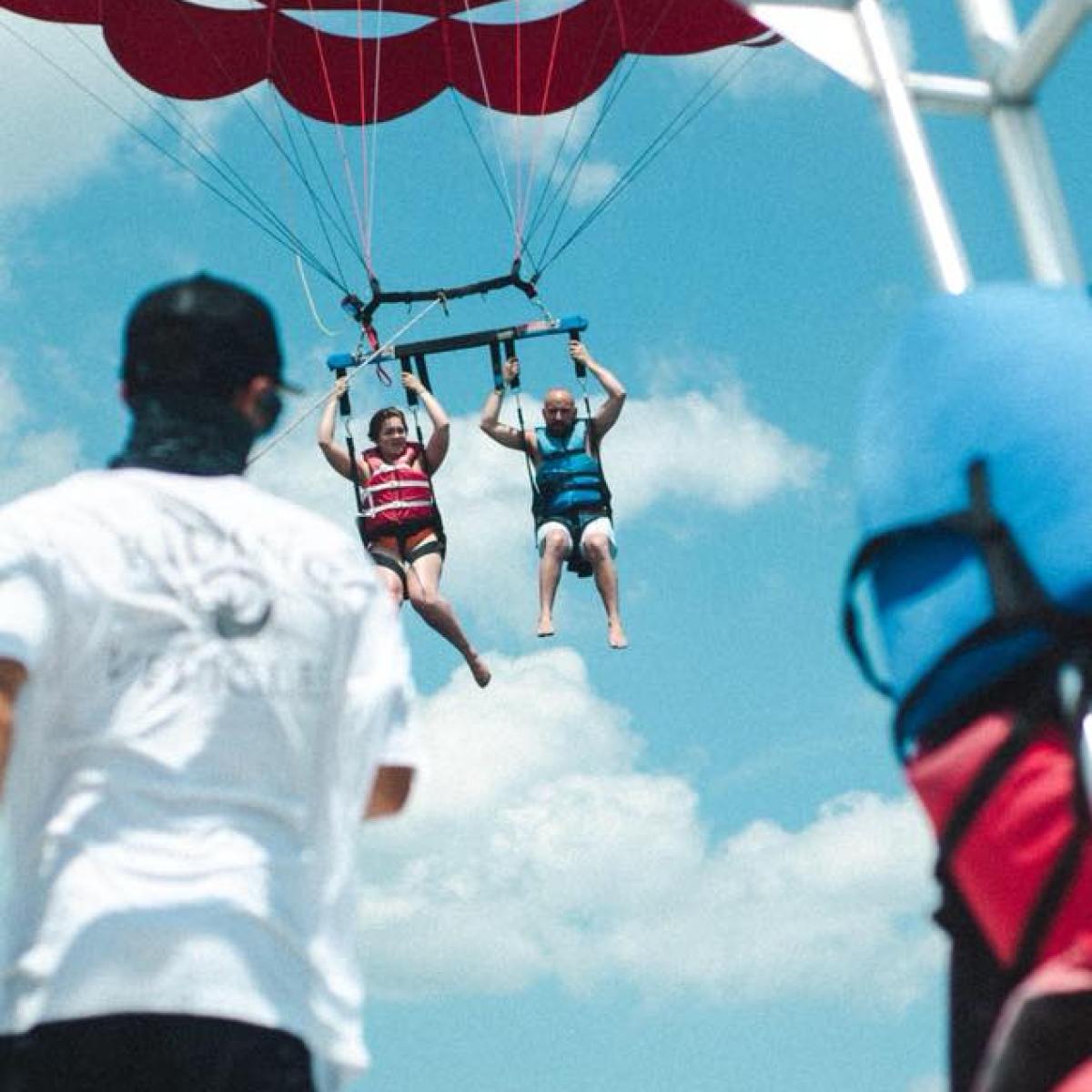 a person flying through the air on a parachute